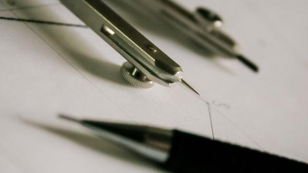 Close-up of a protractor and mechanical pencil on white, blank paper